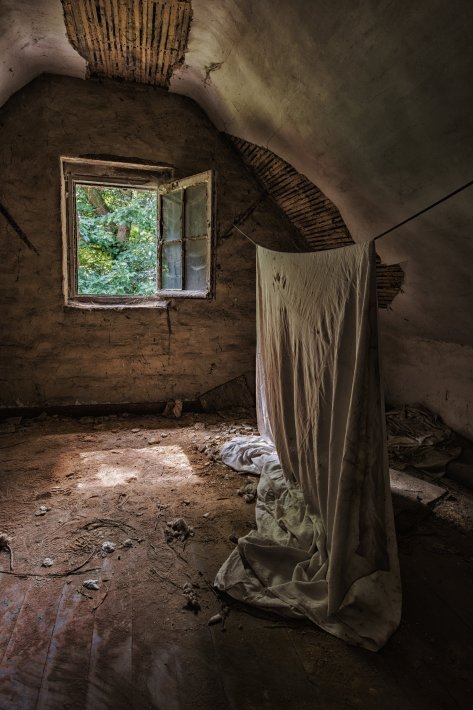 old-rug-hanging-in-the-attic-of-an-abandoned-house.jpg