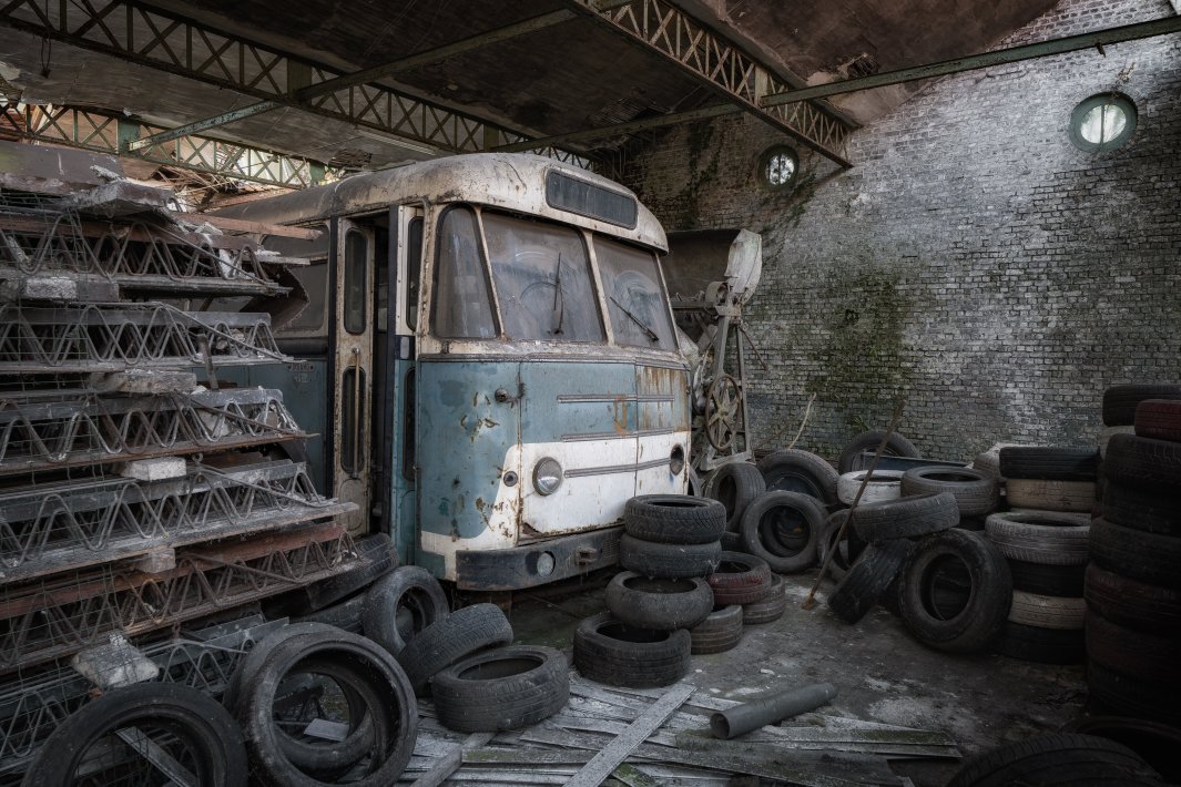an-old-blue-bus-with-tires-surrounded.jpg